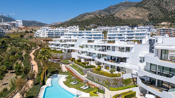 A modern resort with multiple white buildings, a swimming pool, and a mountainous backdrop. - Garden Villa - Large Terrace with Outdoor Kitchen and Pool, Higueron West, Fuengirola (Fuengirola)