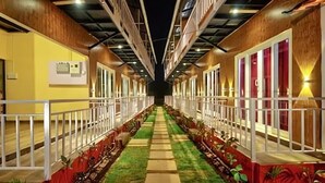 Un couloir avec une allée centrale, des murs en bois et une rambarde de chaque côté.