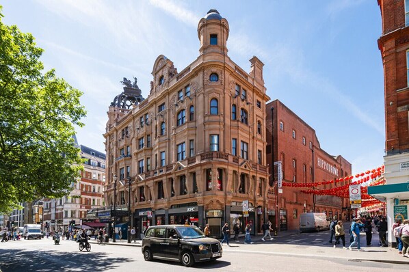 A historic building with ornate architecture, a KFC restaurant, and a visible street with pedestrians and vehicles.