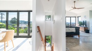 Ein moderner Wohnraum mit Essbereich, einer Treppe und einer Sitzecke mit Fernseher.