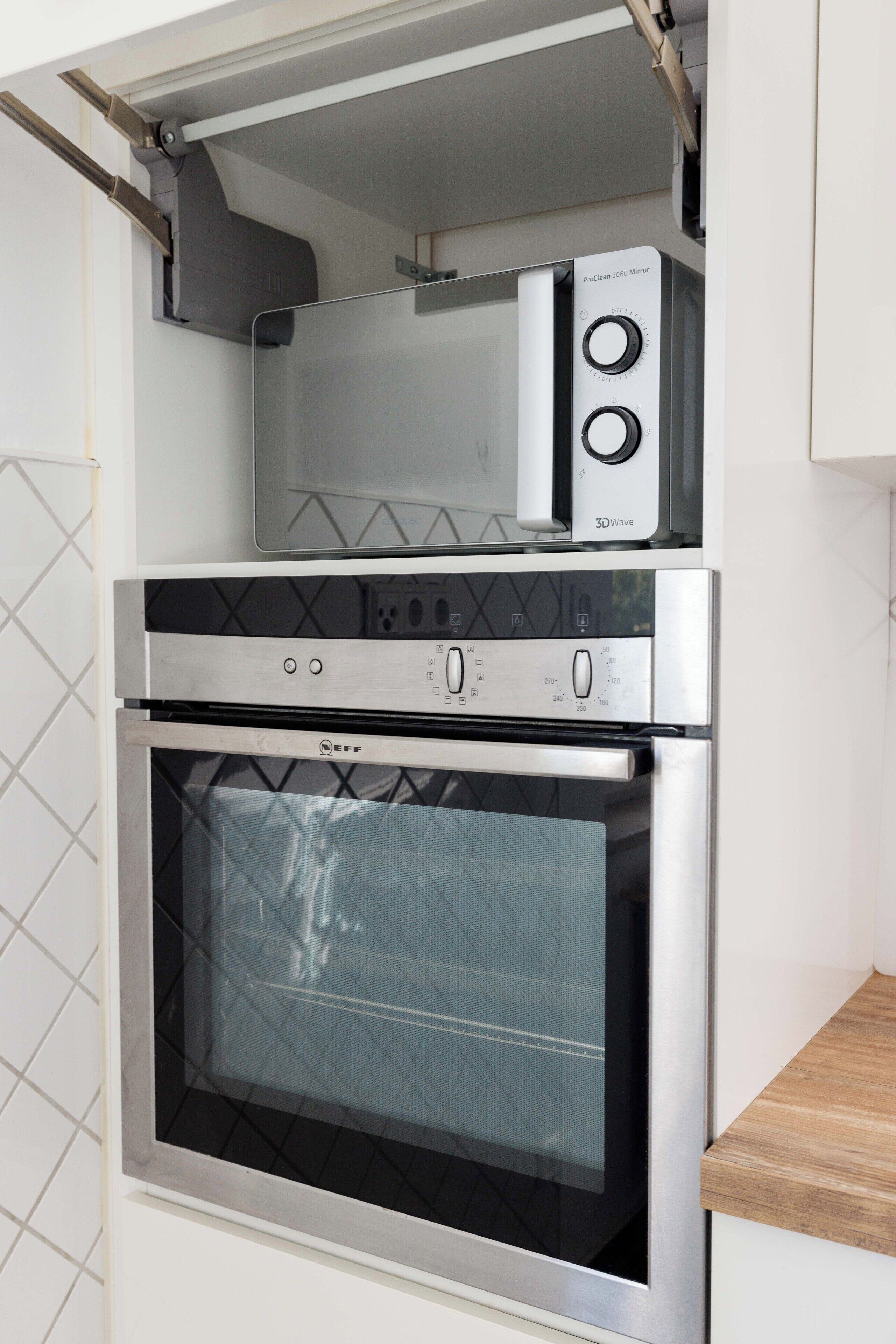 A kitchen with a microwave, oven, and a 3D wave cooking appliance.