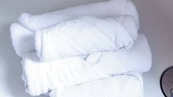 Une pile de serviettes blanches dans le lavabo d’une salle de bain.