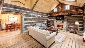 L’intérieur d’un chalet rustique, avec une cheminée en pierre, des meubles en bois et un coin salon confortable.
