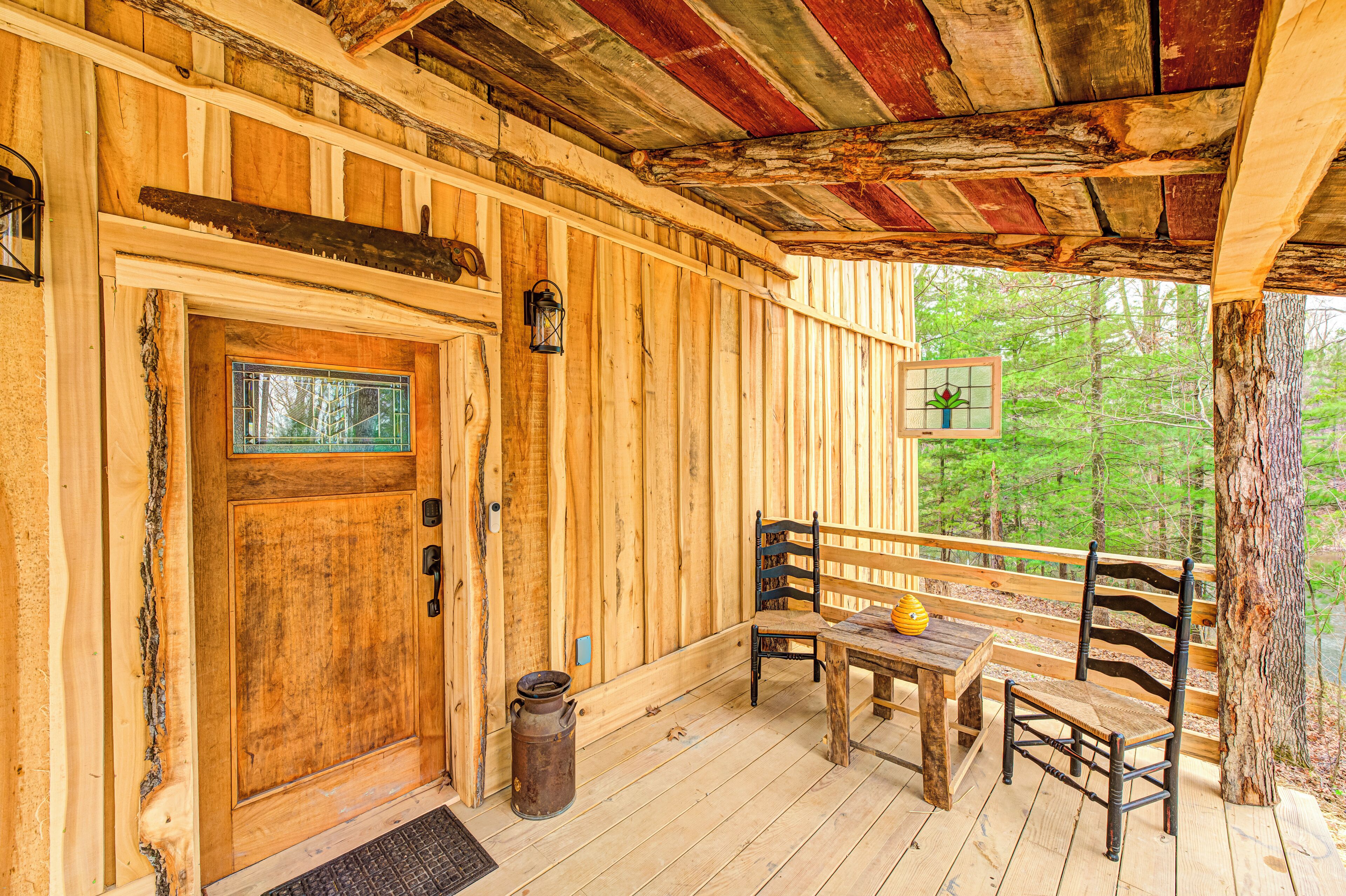 A wooden cabin with a wooden door, a bench, a table, and a lantern.