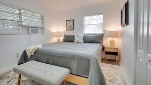 A bedroom with a large bed, bedside tables, and a bench.