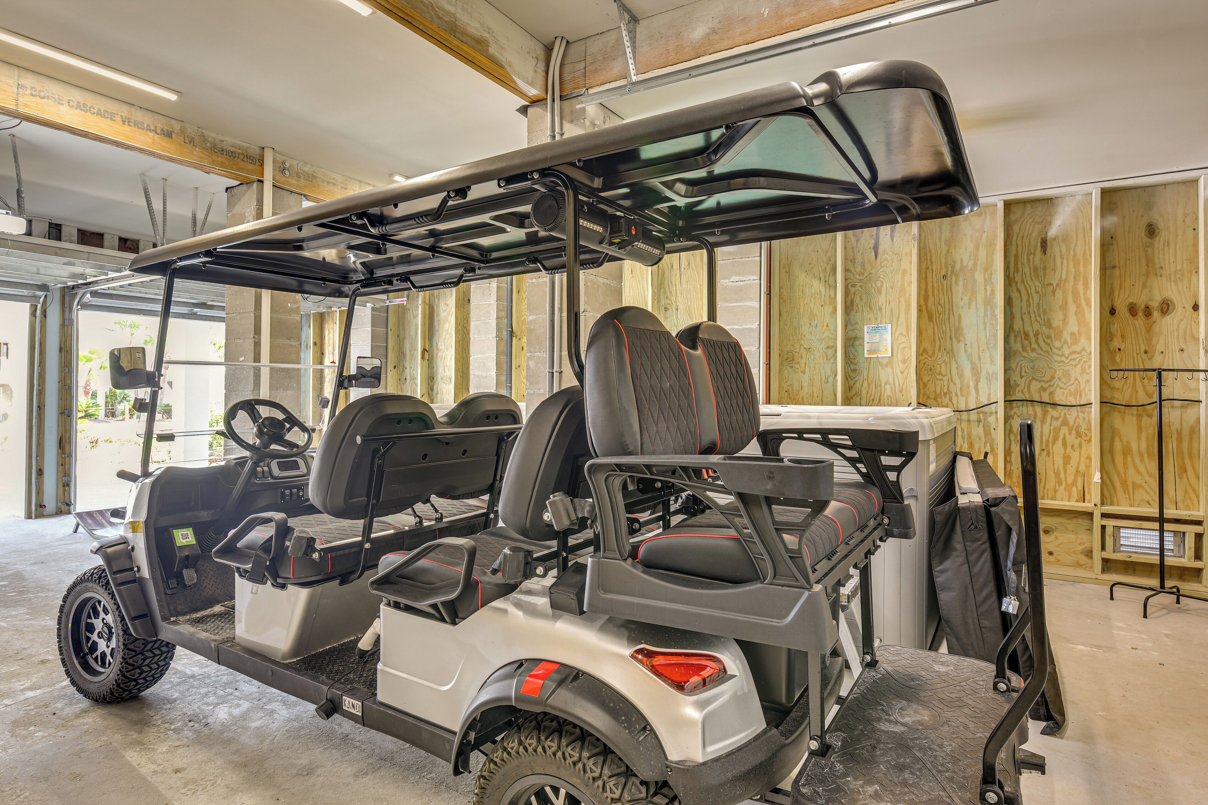 A golf cart with a canopy, two seats, and a steering wheel.