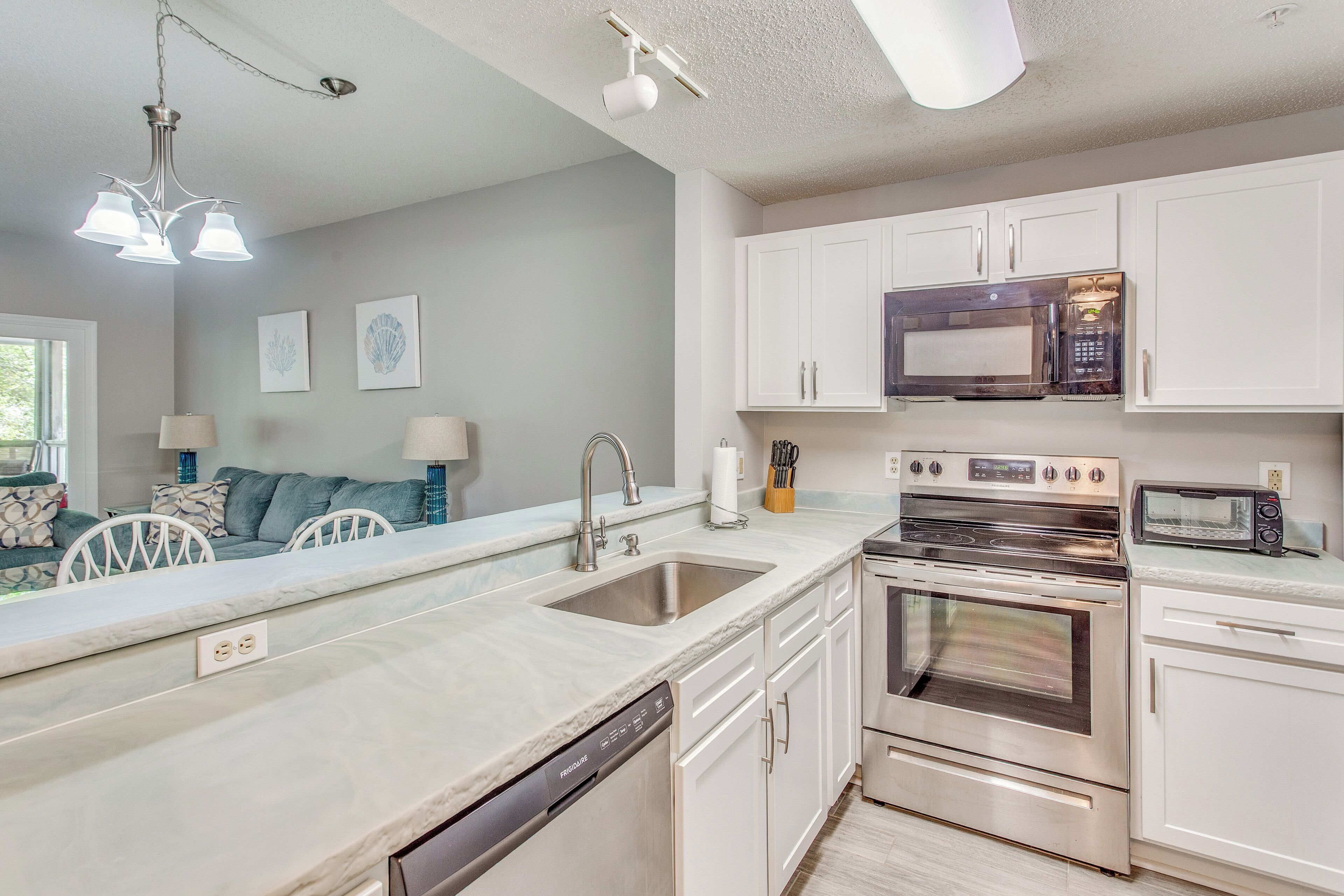 A modern kitchen with stainless steel appliances, white cabinetry, and a dishwasher.