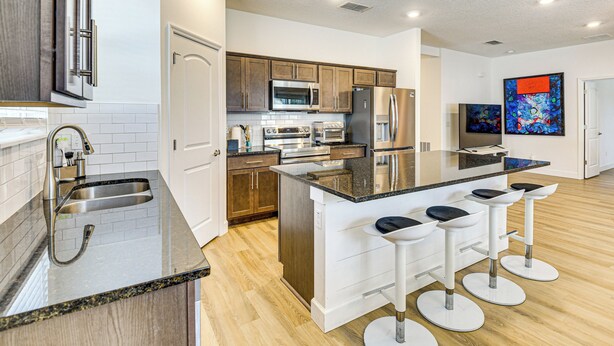 Una cocina moderna con una isla central, electrodomésticos de acero inoxidable y armarios de madera.
