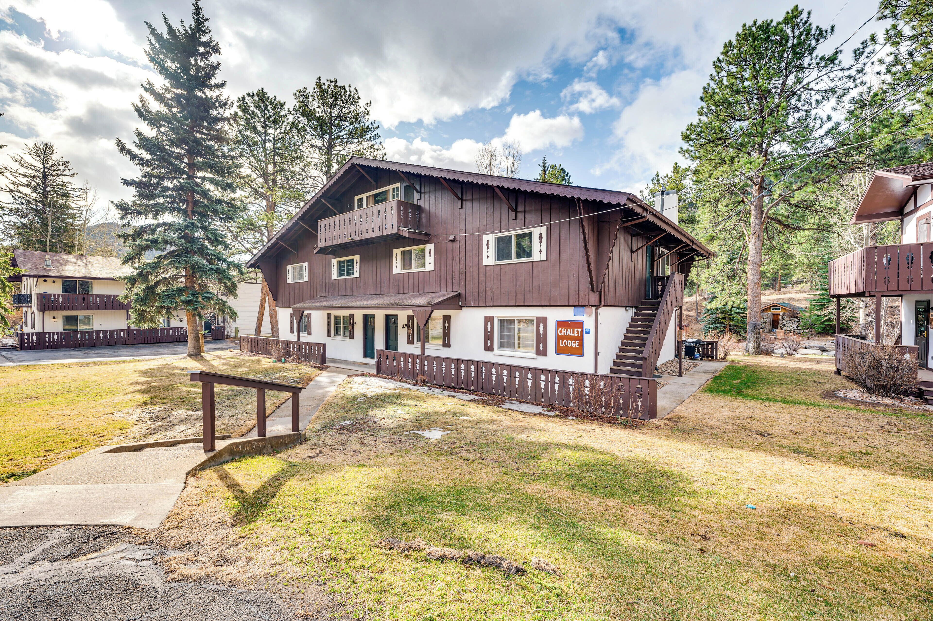 Un hotel de estilo chalet con fachada de madera, varios balcones y un cartel que indica que es un alojamiento tipo chalet.