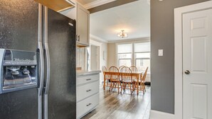 A kitchen with a stainless steel refrigerator, wooden dining table, and chairs. - Walk to Dtwn Green Lake: Peaceful Getaway w/ Porch (Green Lake)