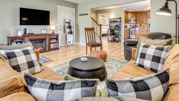 A living room with a sofa set, a coffee table, a television, and a kitchen in the background. - 1 Mi to Dtwn Black Mountain: Home w/ Patio & Yard (Black Mountain)