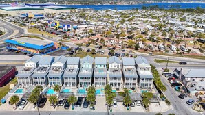 Un hôtel situé en bord de mer, doté de nombreux balcons, d’une piscine et d’un parking.