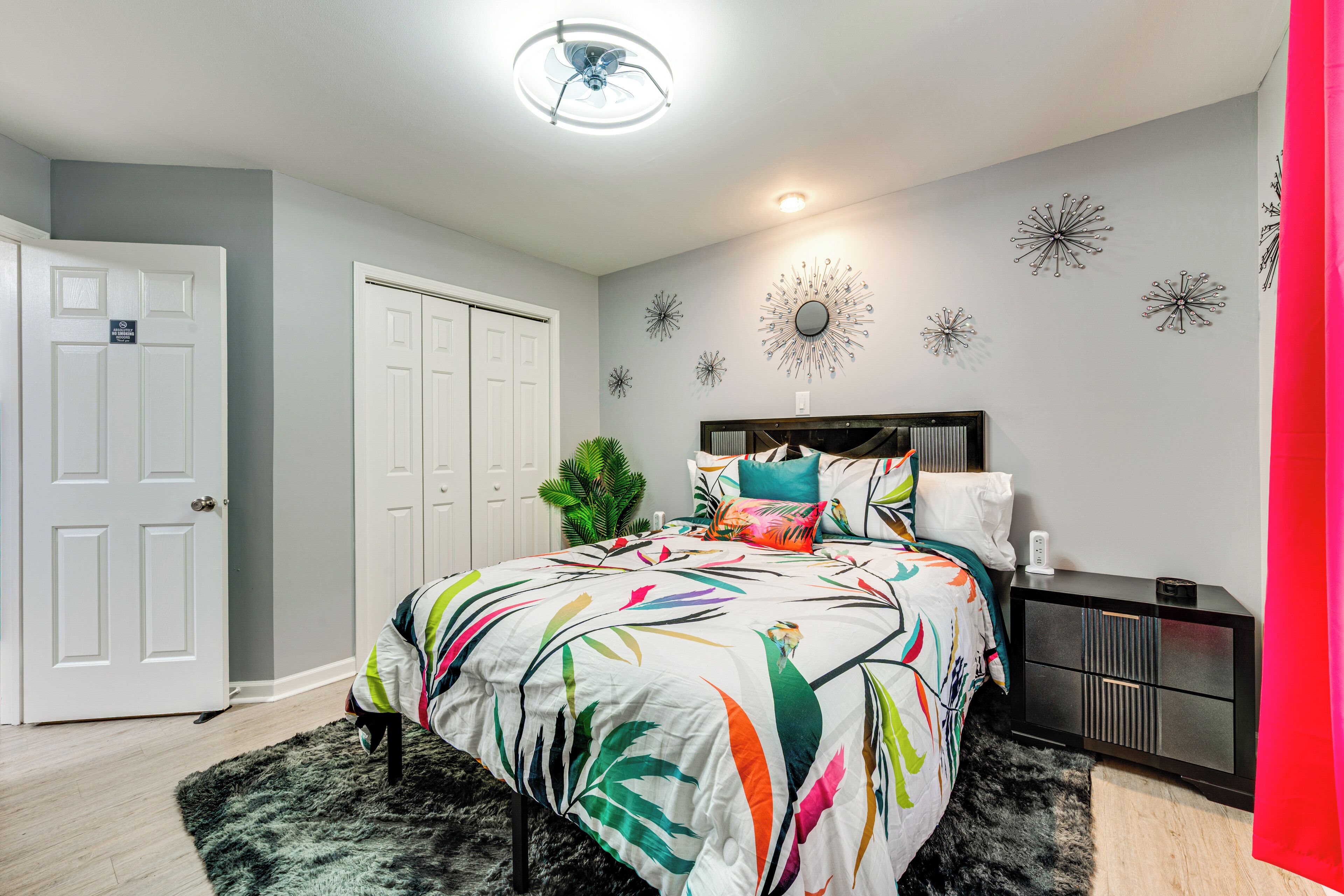 A bedroom with a bed, nightstand, and decorative wall art.
