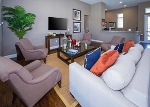 A living room with a white sofa, two armchairs, a coffee table, and a television. - Spacious 4Bd Disney Dream With Resort Access at Lucaya 3210 (Kissimmee)
