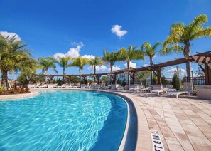 A pool area with clear blue water, surrounded by palm trees and lounge chairs. - Spacious 4Bd Disney Dream With Resort Access at Lucaya 3210 (Kissimmee)