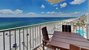 Un balcon avec vue sur une plage et l’océan.
