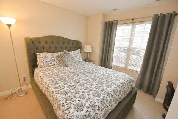 A bedroom with a bed, a lamp, a window with curtains, and a radiator. - Spacious 3br 3. 5 bath townhome w/garage (123p) (South Bend)