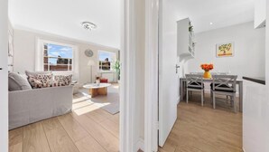 Een moderne woonkamer met een bank, een salontafel en een eethoek met een tafel en stoelen.