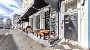 Een restaurant met terras, een glazen deur en het nummer 38 op de deur.