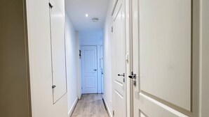 A hallway with wooden flooring and white doors.