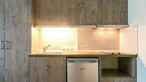 Une cuisine moderne avec des meubles en bois, un lave-vaisselle en acier inoxydable et un éclairage supérieur lumineux.