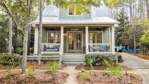 A small, single-story house with a porch, surrounded by trees and a pathway. - Private Pool and LSV Watercolor Getaway (Santa Rosa Beach)