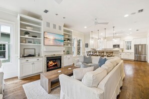 A spacious living room with a fireplace, white sofas, and a wooden coffee table. - Private Pool & Spa Retreat w/ LSV in WaterColor’s Forest District (Santa Rosa Beach)