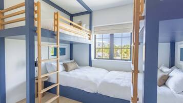 Een slaapkamer met stapelbed, een ladder, een raam met uitzicht en een nachtkastje.