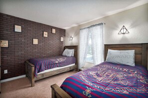Une chambre avec deux lits, un mur en briques et des citations inspirantes.