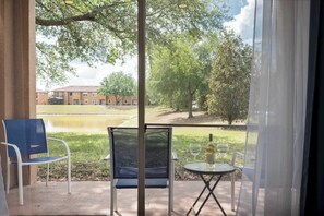 A balcony with a chair, a small table, and a bottle of wine. - Peaceful Townhome w/ Patio & Resort Access (Davenport)