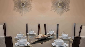 A dining table with a central serving dish, surrounded by white bowls and saucers, set against a wall with decorative sunburst mirrors. - Resort Villa w/ Private Pool & Family Fun (Davenport)
