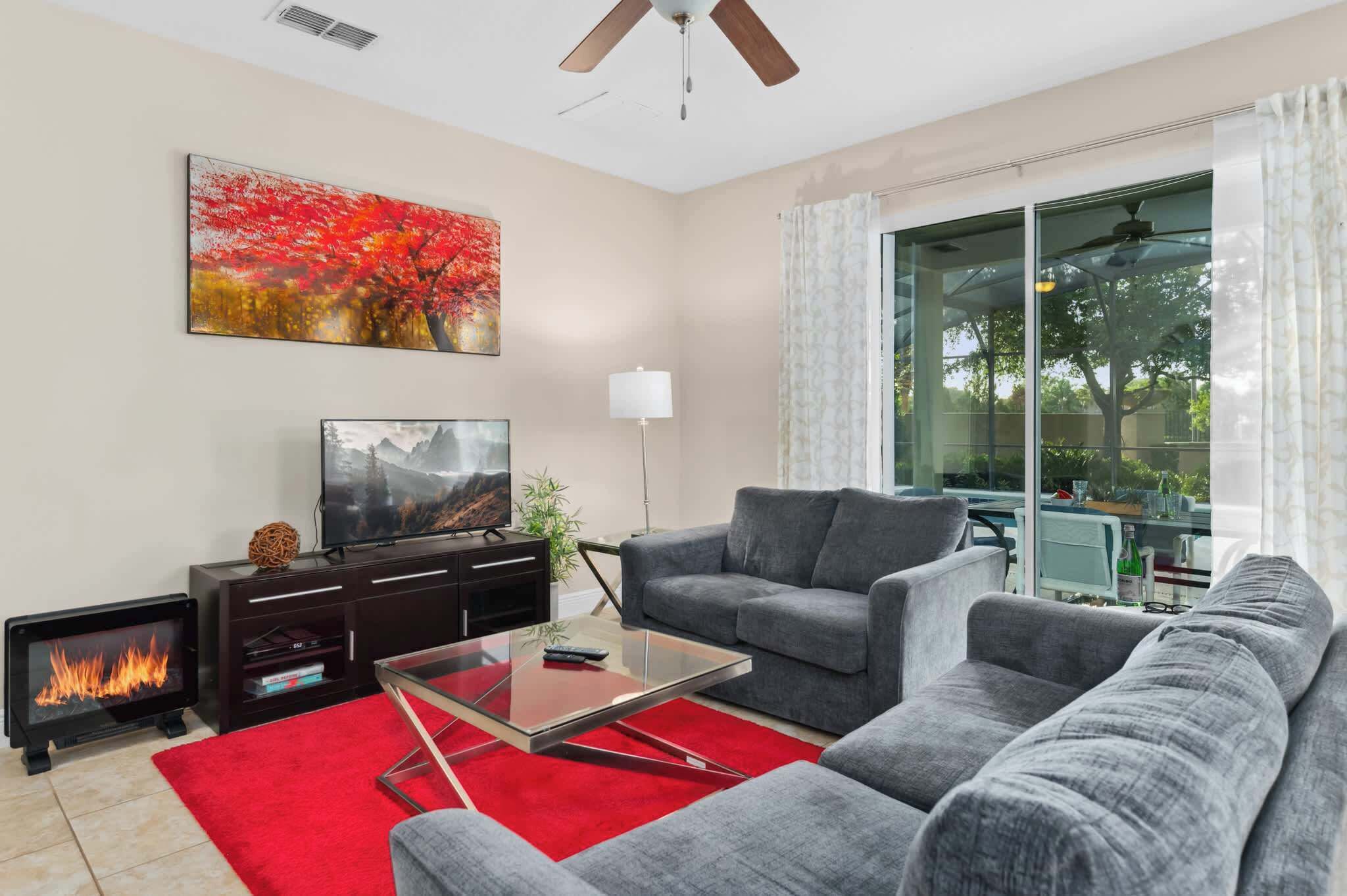 A living room with a fireplace, a sofa, a coffee table, and a TV.