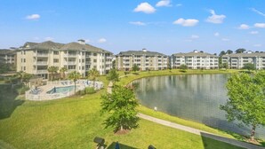 A multi-story hotel with a swimming pool and a lake. - Magnolia Pointe Luster Leaf 4887-201 3 Bedroom Condo (Myrtle Beach)