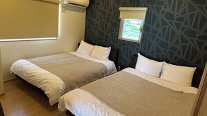 Une chambre d’hôtel avec deux lits, une fenêtre donnant sur un beau paysage et un mur décoré d’un motif.