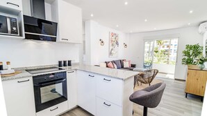 Een moderne keuken met witte kastjes, een ingebouwde oven en een granieten werkblad.