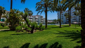 Een resort met palmbomen, een zwembad en een gebouw met balkons.