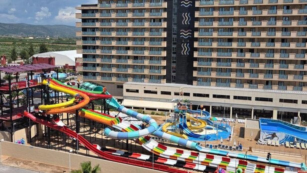 A hotel with multiple balconies and a water park with various slides and pools. - Marina d'Or - Front sea view (Orpesa)