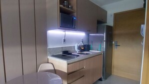 Cocina compacta con microondas, lavaplatos y refrigerador.