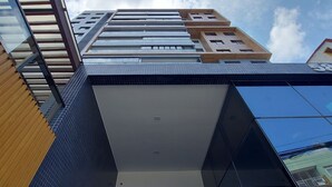 Un edificio moderno con un llamativo letrero con el número '585', amplias ventanas y fachada de vidrio reflectante.