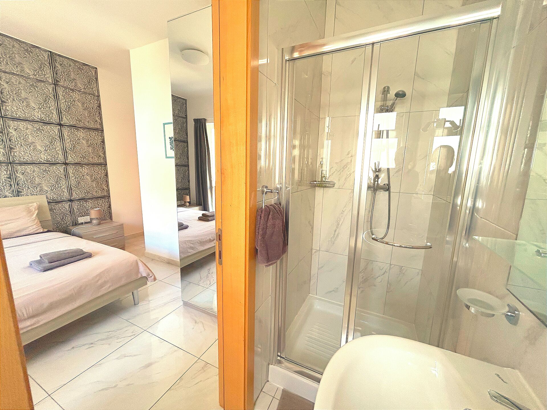 A modern bathroom with a glass-enclosed shower, a white sink, and a toilet.