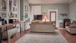 A cozy living room with a sofa, a coffee table, and a television. There is a kitchen area with a stove and a refrigerator. - Shamokin Bed and Breakfast (Shamokin)