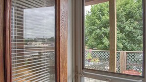 A sliding glass door leading to an outdoor patio area with a view of a tree and a building in the background. - Shamokin Bed and Breakfast (Shamokin)