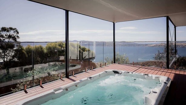 A hot tub area with a view of the sea and hills.