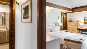 Une chambre à coucher avec un lit, des lampes de chevet, une commode et un miroir.