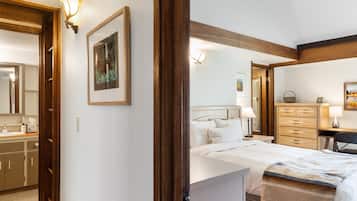 Un dormitorio con cama, lámparas de noche, cómoda y espejo.