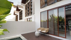 A modern outdoor patio with a pool, wicker chairs, and a sliding glass door leading to a dining area. - Lulu Villa - 2-bedrooms villa in Canggu (Canggu)