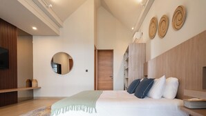 A modern bedroom with a large bed, a round mirror, wooden headboard, and a built-in TV. - Lulu Villa - 2-bedrooms villa in Canggu (Canggu)
