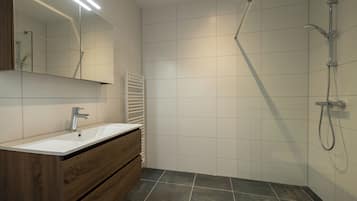 Een douche, een haardroger, handdoeken, toiletpapier