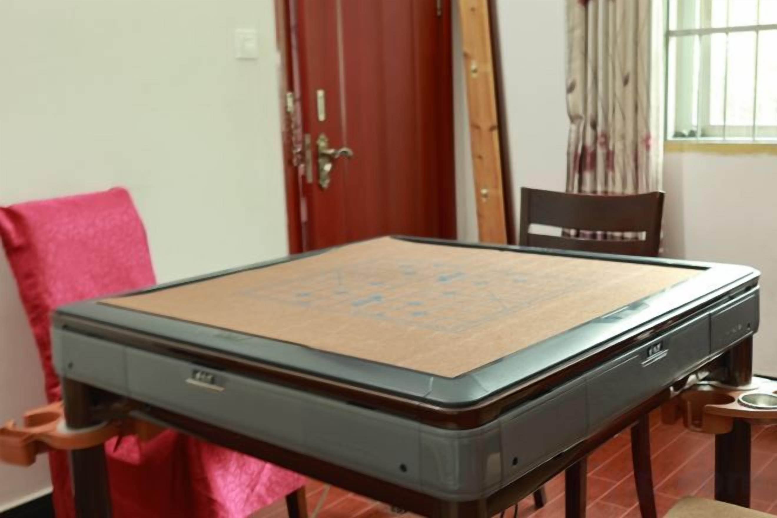 A room with a table that has a mat on top, a chair, and a door in the background.