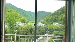 A window with a view of a mountainous landscape and houses.